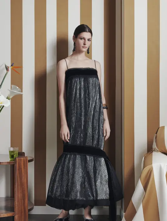 Kali ini gaun hitam tampil dengan sentuhan bulu dengan tali yang tipis. Untuk look kasual tambahkan sepatu balet yang nyaman.  (Foto: Tory Burch Indonesia)