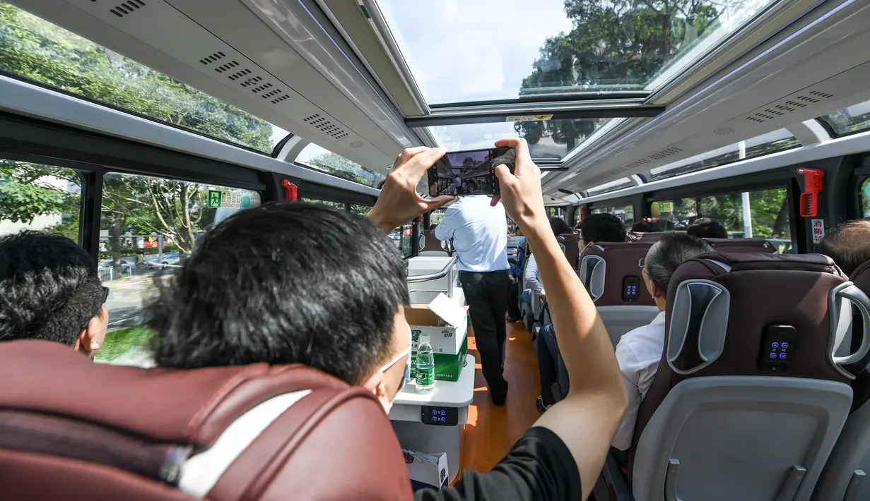 Seorang pria mengambil foto di dalam sebuah bus wisata di Shenzhen, Provinsi Guangdong, China selatan (22/10/2020). Shenzhen pada Kamis (22/10) meluncurkan tiga jalur bus wisata bagi wisatawan, yang masing-masing menampilkan budaya, teknologi, dan pemandangan malam kota tersebut. (Xinhua/Mao Siqian)