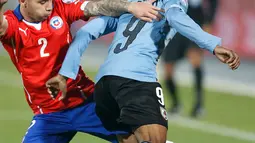 Penyerang Uruguay, Diego Rolan (kanan) berusaha melewati bek Chile, Eugenio Mena di perempat final Copa Amerika 2015 di National Stadium, Santiago, Chile, (25/6/2015). Chile melaju ke semifinal usai mengalahkan Uruguay 1-0. (REUTERS/Ueslei Marcelino)