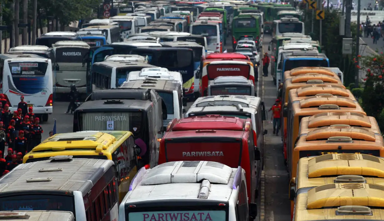 Banyaknya bus-bus yang mengangkut ratusan buruh parkir di badan jalan mengakibatkan kemacetan di kawasan Sudirman, Jakarta, Kamis (1/5/14). (Liputan6.com/Johan Tallo)
