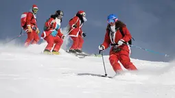 Sejumlah orang mengenakan kostum Santa Claus berselancar diatas salju di resor ski Verbier, Pegunungan Alpen Swiss (2/12). Para pengunjung mengenakan kostum untuk merayakan hari pembukaan musim ski. (AFP Photo/Fabrice Coffrini)
