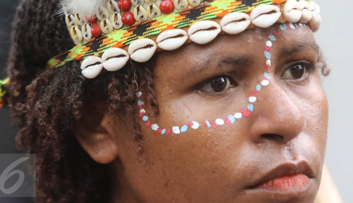 Massa mengenakan kostum tradisional daerah Papua saat berunjuk rasa di depan kantor PT Freeport Indonesia, Jakarta, Senin (20/3). Mereka menuntut areal pertambangan Freeport di Tembagapura, Mimika, Papua, ditutup. (Liputan6.com/Immanuel Antonius)