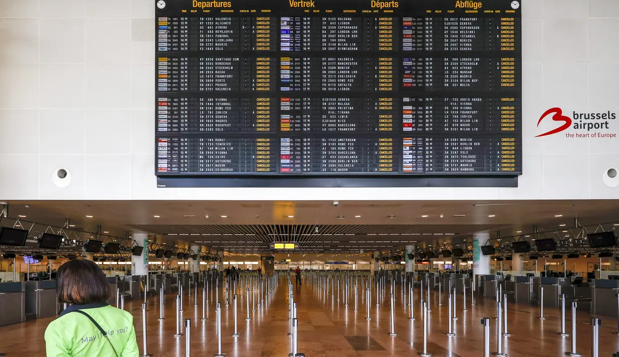 Seorang karyawan berdiri di bawah papan keberangkatan dengan penerbangan yang dibatalkan di ruang keberangkatan di bandara internasional Brussel selama pemogokan nasional di Brussel, Belgia, Senin (20/6/2022). Penumpang diimbau untuk tidak datang ke bandara dan memesan ulang penerbangan mereka. (AP Photo/Olivier Matthys)