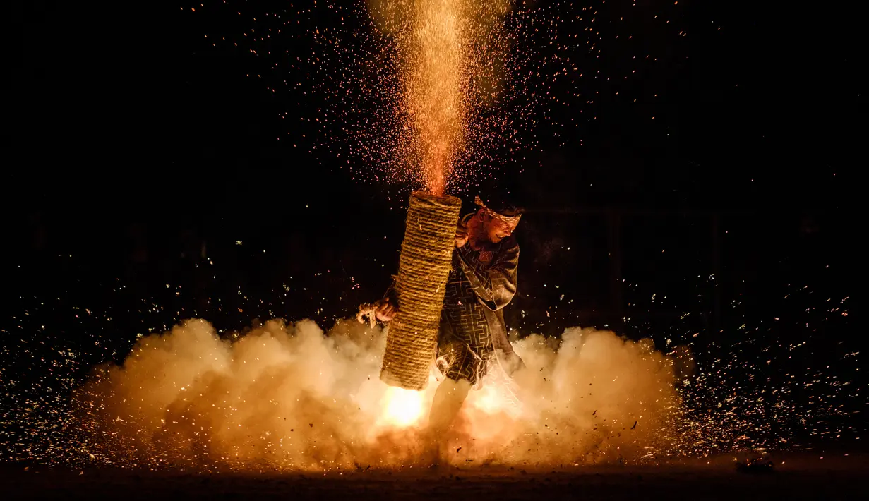 Seorang pria memegang Tezutsu hanabi atau kembang api genggam pada malam Festival Toyohashi Gion di Toyohashi, Jepang, Jumat (20/7). Acara ini didedikasikan untuk Kuil Yoshida sebagai bagian dari ritual Shinto. (Yasuyoshi CHIBA/AFP)