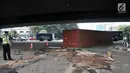 Petugas berjaga di dekat kontainer pasca kecelakaan di kolong flyover Tomang, Jakarta, Kamis (28/6). Kecelakaan tersebut diduga akibat truk kelebihan muatan dan beruntung sang sopir hanya mengalami luka ringan. (Merdeka.com/Iqbal S. Nugroho)