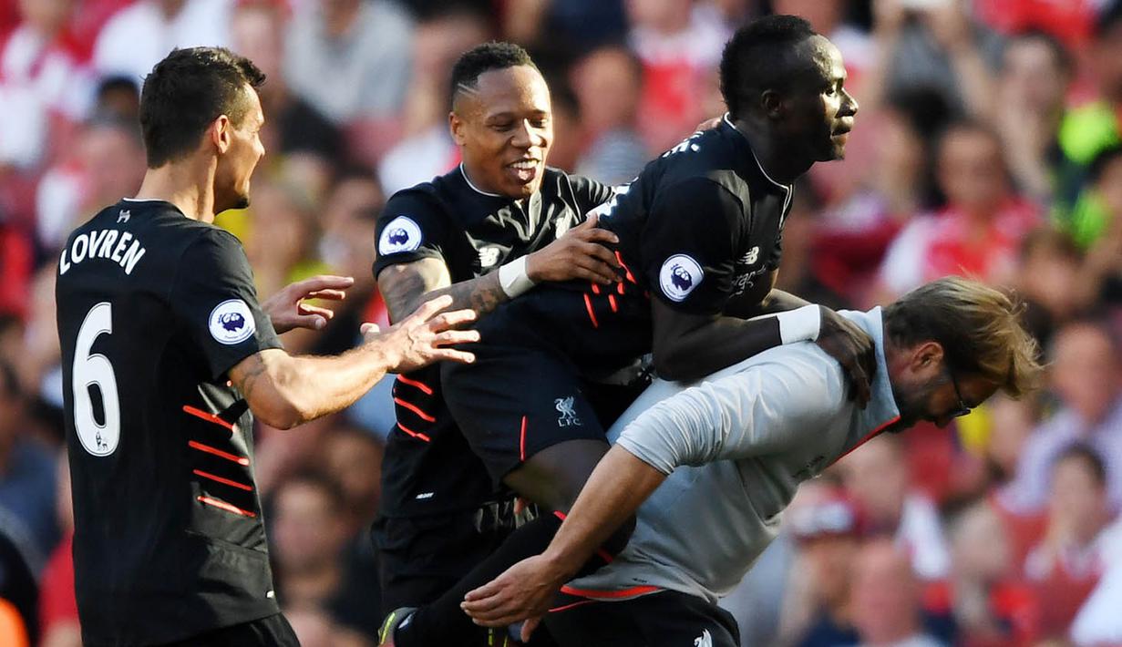 Penyerang Liverpool, Sadio Mane, bersama sang pelatih, Juergen Klopp merayakan gol yang dicetaknya ke gawang Arsenal. Mane berhasil mencetak gol pada laga debut resminya bersama The Reds. (Reuters/Tony O'Brien)