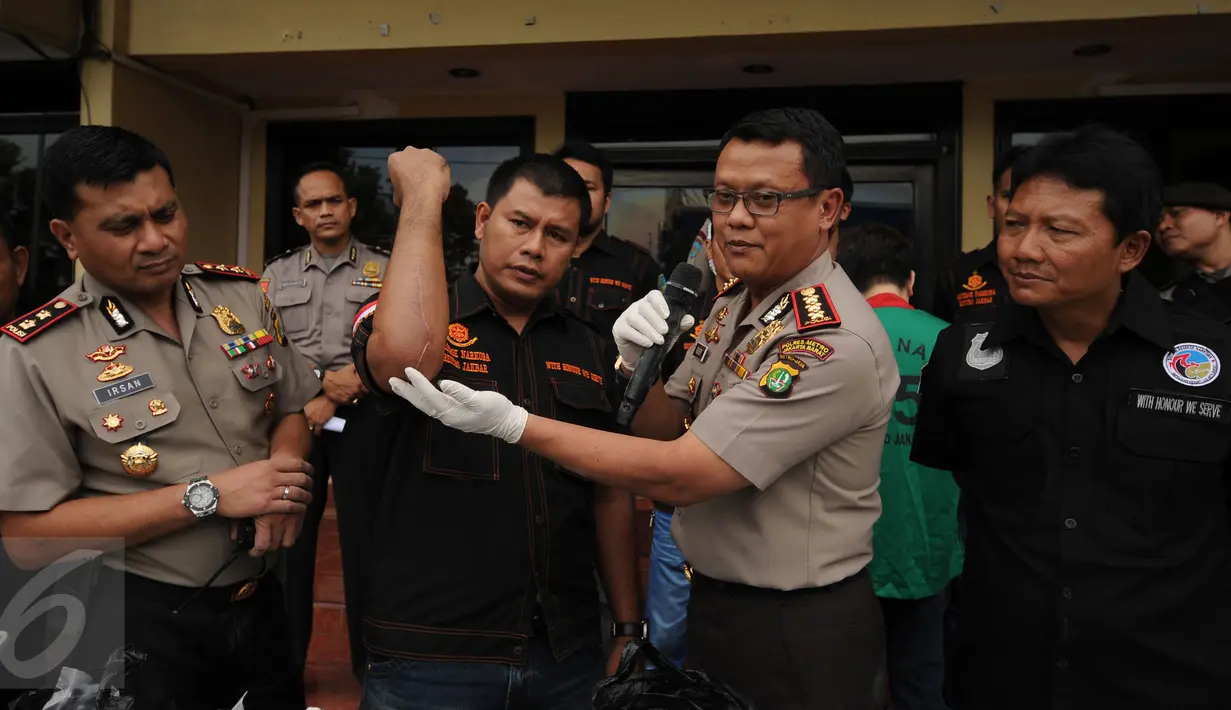 Kapolres Jakarta Barat, Kombes (Pol) Rudy Heriyanto AN (kedua kanan) menunjukkan luka tembak yang dialami timnya saat melakukan penangkapan tersangka pengedar narkotika jenis sabu di Jakarta, Rabu (23/3/2016). (Liputan6.com/Helmi Fithriansyah)