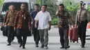 Gubernur Aceh Irwandi Yusuf dengan pengawalan petugas tiba di Gedung KPK, Jakarta, Rabu (4/7). Saat turun dari mobil tahanan, terlihat salah satu petugas KPK membawa satu koper berwarna merah tua. (Merdeka.com/Dwi Narwoko)