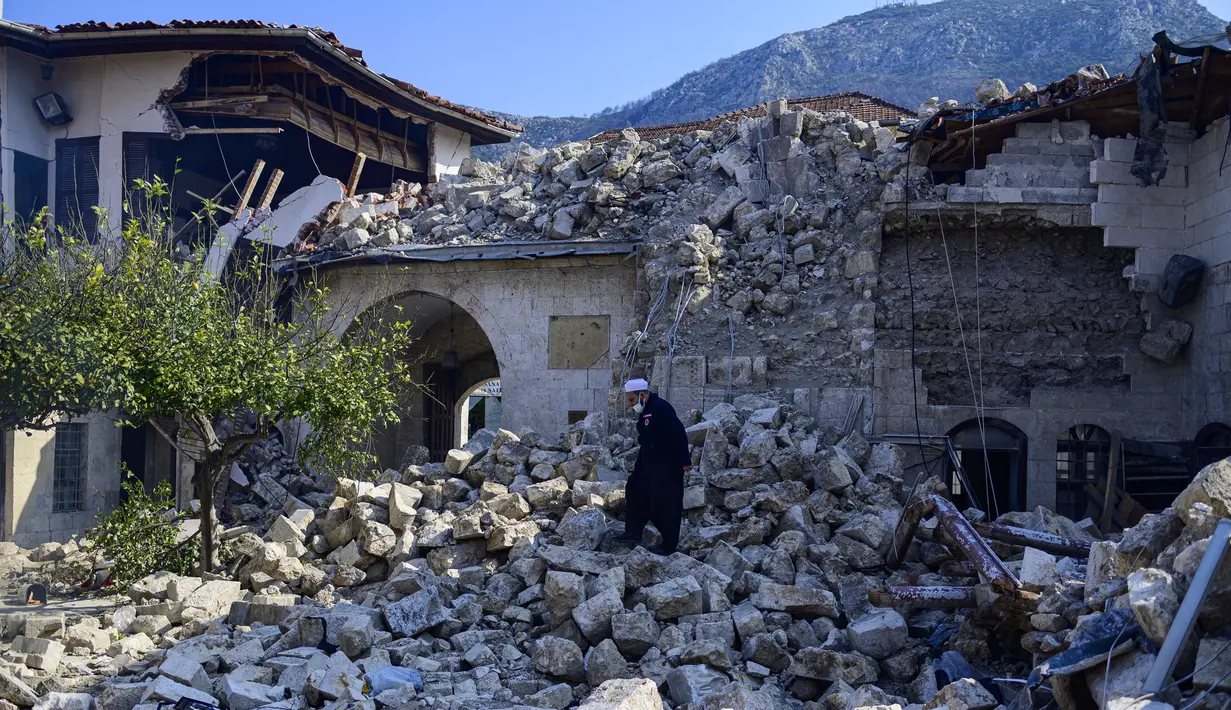 Seorang penduduk setempat memeriksa masjid Habib-i Neccar yang hancur di kota selatan bersejarah Antakya pada 11 Februari 2023, setelah gempa berkekuatan 7,8 melanda tenggara Turki. Gempa itu juga mengakibatkan hilangnya warisan negara yang kaya, yaitu Masjid Habibi Neccar yang berusia berabad-abad lamanya. (Photo by Yasin AKGUL / AFP)