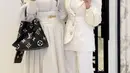 Venna Melinda juga hadir mengenakan atasan lengan panjang berkerah tinggi, serta bordiran bunga, dipadukan rok flowy putih panjang. [@vennamelindareal]