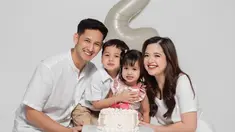 Anak keduanya genap berusia dua tahun, kebahagiaan terpancar jelas di wajah Tasya Kamila dan Randi Bachtiar. Tasya Kamila, Randi, dan si sulung Arassya selaras mengenakan busana putih, sementara Shafanina mengenakan dress simpel floral warna merah muda. Rambut gadis kecil yang akrab disapan Shanin itu dikepang dua sehingga membuatnya terlihat menggemaskan. (Liputan6.com/IG/@tasyakamila)