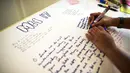 Jumat (18/7/14), Seorang wanita di Kuala Lumpur menulis pesan berisi doa bagi para korban jatuhnya pesawat Malaysia Airlines MH17. (REUTERS/Athit Perawongmetha)