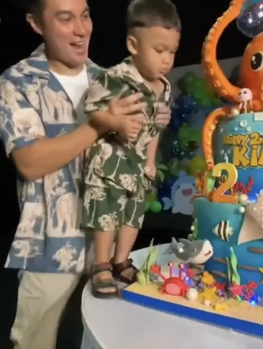 Bedanya, Baim dan Paula mengenakan pakaian di dominasi warna biru. Sedangkan Kiano one set warna hijau dengan gambar gajah mendominasi. Baim dan Paula sama-sama mengenakan sneakers putih, sedangkan Kiano mengenalam sandal. Tangkapan layar @baimwong