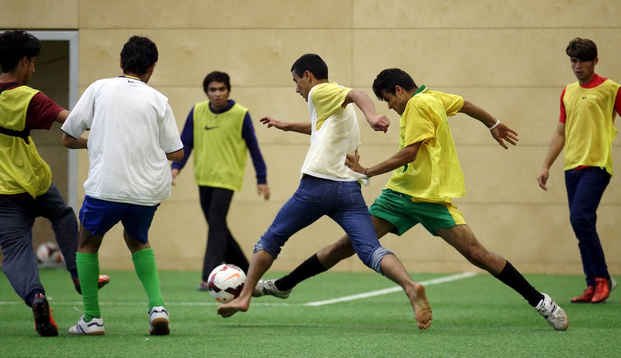 Para imigran bermain sepak bola di bawah bimbingan pelatih profesional dari klub FK Austria Wien di Wina, Austria. (Reuters/Heinz-Peter Bader)