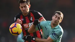 Aksi Henrikh Mkhitaryan berduel dengan pemain Bournemouth, Charlie Daniels pada laga lanjutan Premier League yang berlangsung di stadion Dean Court, Inggris, Minggu (25/11).  Arsenal menang 2-1. (AFP/Glyn Kirk)