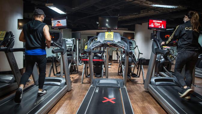 Orang-orang berolahraga di sebuah tempat gym yang menerapkan jarak fisik di Surabaya, Rabu (21/10/2020). Pusat kebugaran itu dibuka dengan menerapkan protokol kesehatan sebagai pencegahan COVID-19. (Juni Kriswanto / AFP)