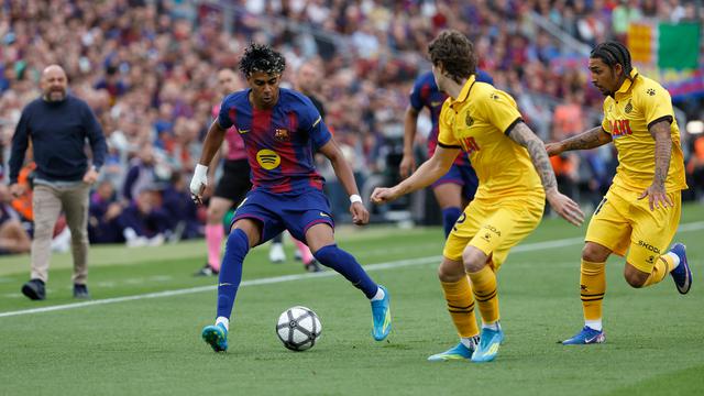 Pemain Barcelona Lamine Yamal (kiri) berebut bola dengan pemain Espanyol Tyrhys Dolan dan Carlos Romero