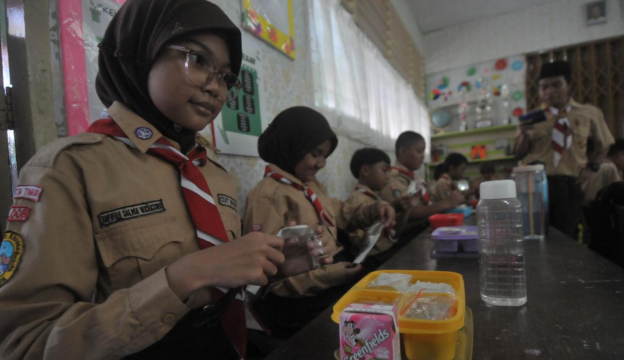 Siswa-siswi SDN 05 dan 07 Cipinang Melayu Kecamatan Makasar, Jakarta bersiap melakukan makan siang bersama, Rabu (7/8/2024). (merdeka.com/Imam Buhori)