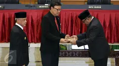 Gubernur Banten Rano Karno (kanan) memberikan surat Pelaksana Tugas Gubernur kepada Mendagri Tjahjo Kumolo (tengah) saat prosesi peresmian Plt Gubernur dan Serah Terima Nota Pengantar Tugas di Kemendagri, Jakarta, Rabu (26/10). (Liputan6.com/Johan Tallo)