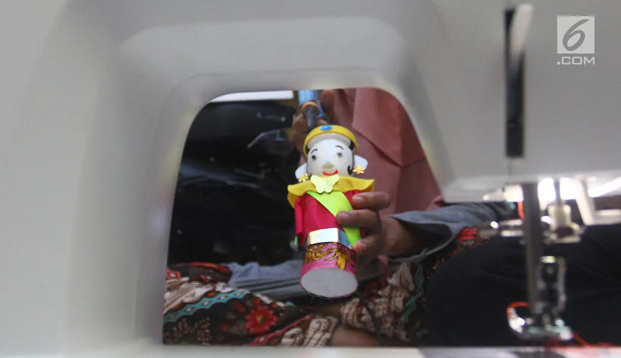 Perajin menyelesaikan pembuatan miniatur ondel-ondel di rumah produksi Kramat Jati, Jakarta, Senin (23/6/2019). Perajin dapat memproduksi 50  hingga 80 miniatur ondel-ondel dalam sebulan. (merdeka.com/Arie Basuki)