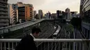 Seorang pria berjalan di jembatan saat kereta Yamanote Line berangkat dari Stasiun Ikebukuro di Tokyo, Jepang, Rabu (22/5/2019). (AP Photo/Jae C. Hong)