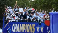 Pemain timnas Prancis, Raphael Varane memegang trofi Piala Dunia 2018 saat pawai dengan bus atap terbuka di sepanjang Champs Elysees, Paris, Senin (16/7). Prancis meraih trofi Piala Dunia kedua usai mengalahkan Kroasia. (Eric Feferberg/Pool via AP)