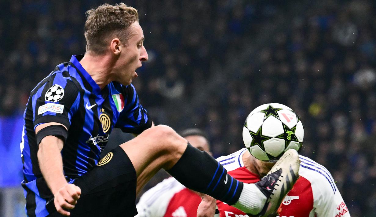 Pemain Inter Milan, Davide Frattesi, berebut bola dengan pemain Arsenal, William Saliba, pada laga Liga Champions di Stadion Giuseppe Meazza, Kamis (07/11/2024). (AFP/Marco Bertorello)