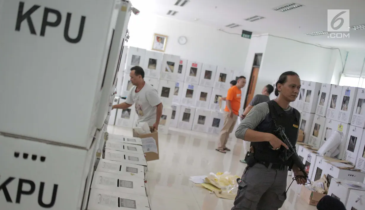 Polisi menjaga kotak logistik hasil Pemilu 2019 di Kecamatan Menteng, Jakarta, Kamis (18/4). Komisi Independen Pemilihan (KIP) menargekan distribusi logistik hasil pemilu dari TPS ke tingkat PPK di daerah selesai dalam sehari dan dilanjutkan rekapitulasi pada 19 April. (Liputan6.com/Faizal Fanani)