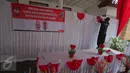 Pekerja memasang pernak-pernik di TPS 4 Kelurahan Gambir, Jalan Tanah Abang Timur, Jakarta, Selasa (18/4). Nantinya Presiden Joko Widodo akan melaksanakan pencoblosan hak suaranya pada Pilkada DKI 2017 di TPS tersebut. (Liputan6.com/Faizal Fanani)