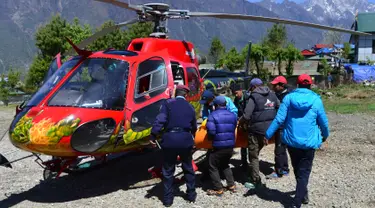 Petugas memasukkan jasad pendaki gunung tertua di dunia asal Nepal, Min Bahadur Sherchan, yang tewas di puncak Pegunungan Everest ke dalam helikopter, Minggu (7/5). Kakek 85 tahun itu ditemukan meninggal di basecamp-nya pada Sabtu. (PRAKASH MATHEMA/AFP)