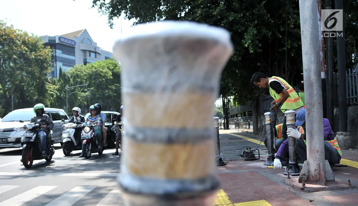 Pekerja memasang Bolar atau tiang pembatas pedestrian di kawasan Tugu Tani, Jakarta, Minggu (9/9). Pemasangan Bolar bertujuan menjaga keindahan jalur pedestrian dan mencegah penyalahgunaan fungsi.(merdeka.com/ Iqbal S. Nugroho)