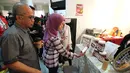 Dirut Bank DKI Kresno Sediarsi dan istri sedang betransaksi menggunakan JakOne Mobile Bank DKI yang telah mencapai 10 ribu pengguna hingga Oktober 2017, di gerai kopi pada festival seni Alpus Incredibles 6 di Jakarta (28/10). (Liputan6.com/Pool/Rudi)