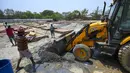 Para buruh bekerja membangun tempat kremasi di ladang kosong di New Delhi, India, Rabu (5/5/2021). Kasus COVID-19 di India sudah tembus angka 20 juta. (Money SHARMA/AFP)