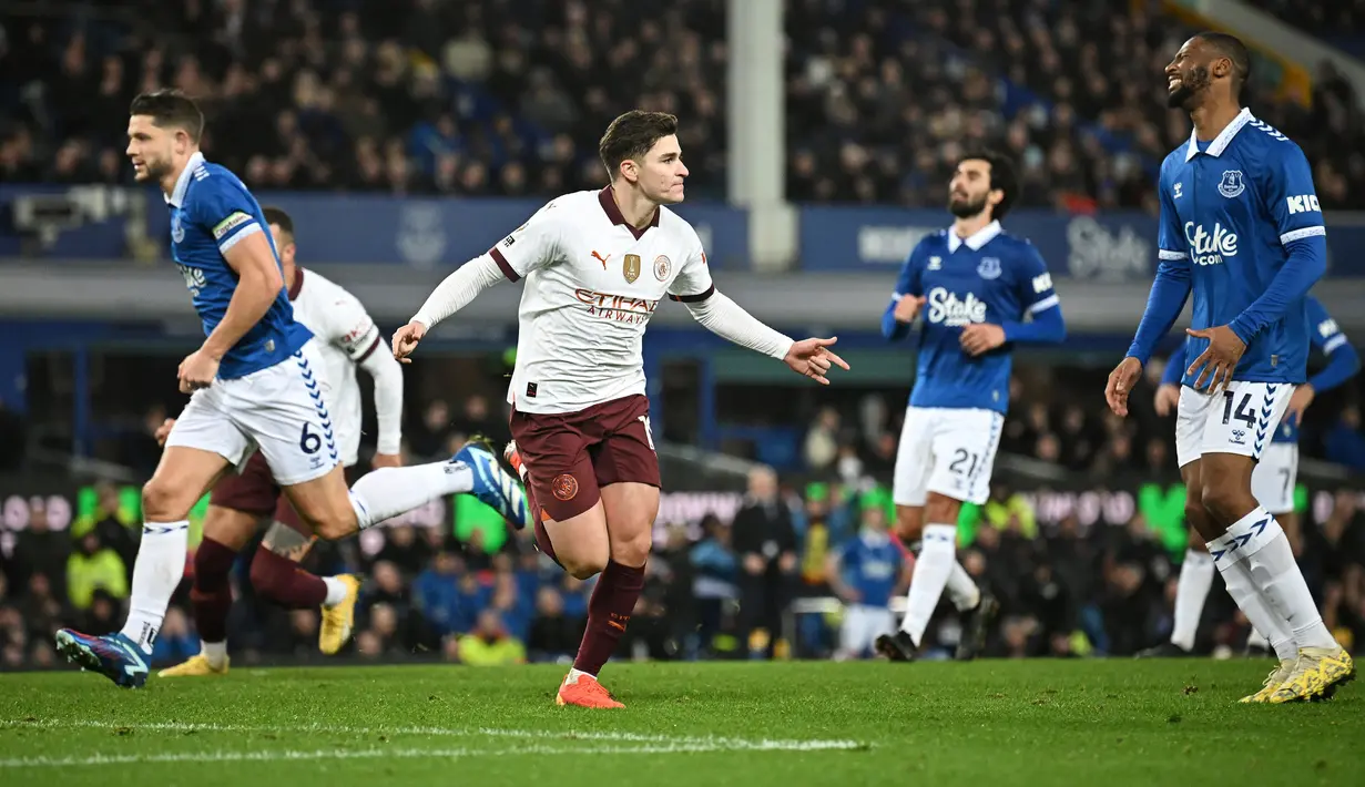 Pemain Manchester City, Julian Alvarez melakukan selebrasi setelah mencetak gol melalui tendangan penalti pada laga lanjutan Liga Inggris 2023/2024 melawan Everton di Goodison Park, Liverpool, Inggris, Kamis (28/12/2023) dini hari WIB. (AFP/Paul Ellis)