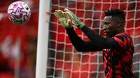Kiper Manchester United asal Kamerun bernomor punggung 24, Andre Onana, melakukan pemanasan sebelum pertandingan Liga Inggris antara Manchester United dan Burnley di Old Trafford, Manchester, barat laut Inggris, pada 30 Agustus 2025. (Oli SCARFF/AFP)