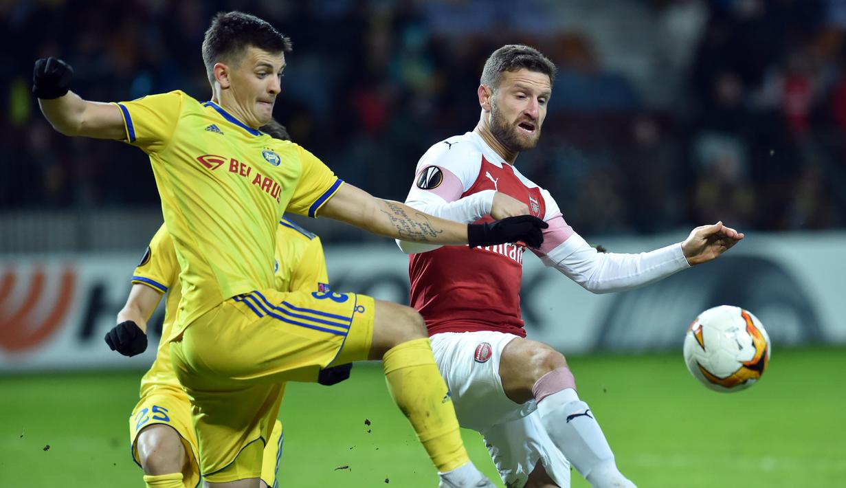 Duel antara Skhordan Mustafi dan Stanislav Dragun pada leg 1,32 besar Liga Europa yang berlangsung di stadion Borisov Arena, Borisov, Jumat (15/2). Arsenal tumbang 0-1 kontra Bate Borisov. (AFP/Sergei Gapon)