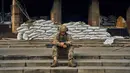Seorang tentara Ukraina beristirahat di tangga Balai Kota di Izium, wilayah Kharkiv, Ukraina, 13 September 2022. Pasukan Ukraina juga berhasil membebaskan lebih dari 40 permukiman di Kharkiv. (AP Photo/Kostiantyn Liberov)