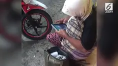 Seorang pengemis terlihat memiliki sebuah smartphone.