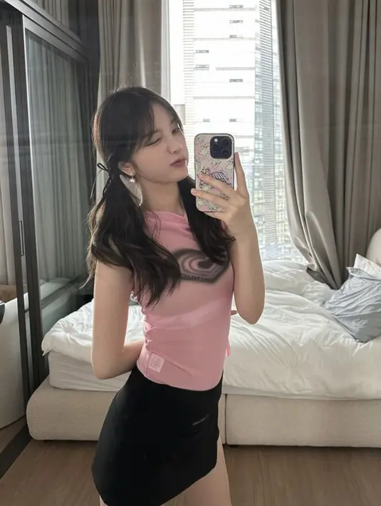 Ia juga tampil dengan atasan pink tanpa lengan transparan dipadukan mini skirt hitamnya. Rambutnya pun diikat dua. (@xooos_)