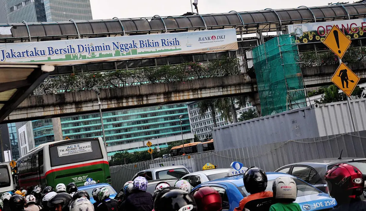 Aksi nekat yang dilakukan pria misterius itu menarik perhatian sejumlah pengguna jalan yang melintas di Jl MH Thamrin, Jakarta, (25/7/2014). (Liputan6.com/Faizal Fanani)