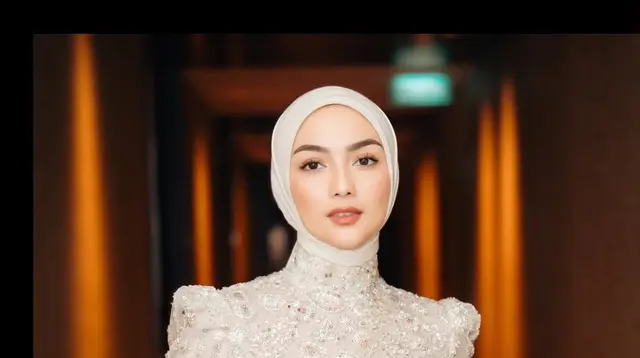 Tampil anggun dalam balutan dress brokat berwarna beige, Citra memadukannya dengan hijab segi empat yang dililit rapi ke belakang. Siluet clean dan warna lembut menciptakan kesan feminin sekaligus classy. [@ciraciki].