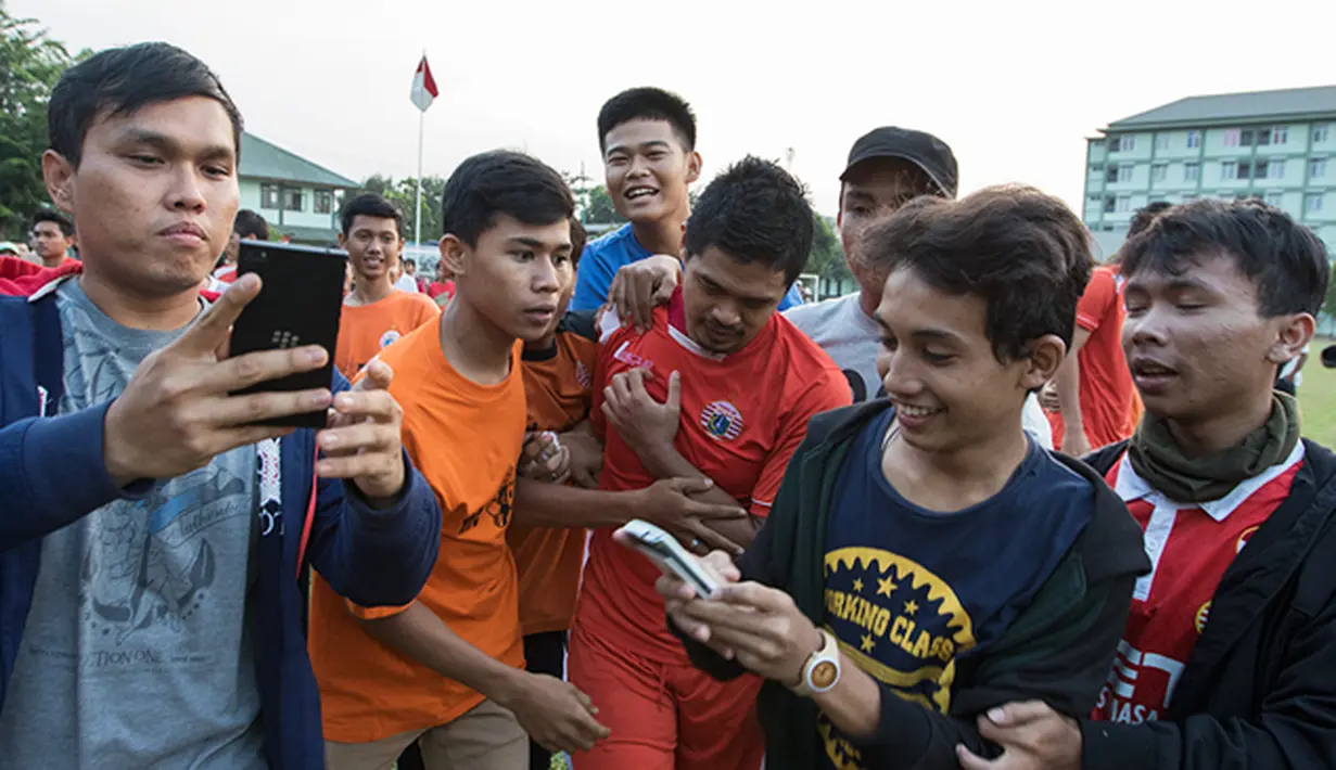 Sejumlah The Jakmania mendekati penyerang Persija Jakarta, Bambang Pamungkas usai mengikuti latihan bersama tim Macan Kemayoran jelang Piala Presiden 2015 di Lapangan Yon Zikon 14, Jakarta, Senin (24/8/2015). (Bola.com/Vitalis Yogi Trisna)
