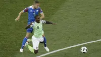 Pemain Nigeria, Odion Ighalo (kanan) jatuh saat berebut bola dengan pemain Islandia, Sverrir Ingason pada laga grup D Piala Dunia 2018 di Volgograd Arena, Volgograd, Rusia, (22/6/2018). Nigeria menang 2-0. (AP/Themba Hadebe)