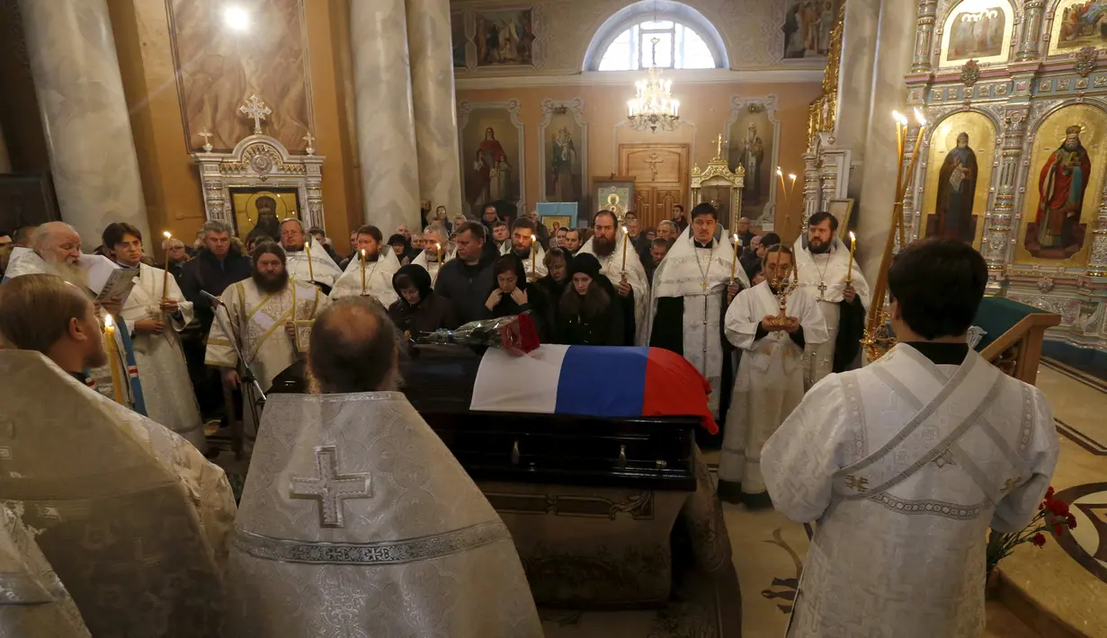Imam Ortodoks memimpin upacara pemakaman pilot asal Rusia, Oleg Peshkov di Lipetsk, Rusia, Rabu (2/12). Oleg Peshkov adalah pilot yang tewas saat pesawat tempur Su-24 yang dikemudikannya ditembak jatuh Turki pekan lalu. (REUTERS/Maxim Zmeyev)