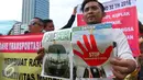 Seorang driver online memperlihatkan poster yang berisi tuntutannya saat unjuk rasa di depan DPR, Jakarta, Senin (22/8). Aksi tersebut untuk penolakan Peraturan Menteri Perhubungan (Permenhub) No 32 Tahun 3016. (Liputan6.com/Angga Yuniar)