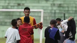 Pemain Arema FC, Hanif Sjahbandi, foto bersama dengan fans usai sesi latihan di Stadion Gajayana, Malang, Kamis (11/4). Setelah sesi latihan, pemain Arema FC melayani permintaan fans untuk foto bersama. (Bola.com/Yoppy Renato)