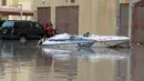 Seorang pria duduk di atas perahu di sebuah jalan yang terendam banjir menyusul hujan lebat di Kegubernuran Mubarak Al-Kabeer, Kuwait (29/11/2020). Hujan lebat melanda Kuwait pada Sabtu (28/11) malam dan Minggu (29/11) pagi waktu setempat. (Xinhua/Asad)