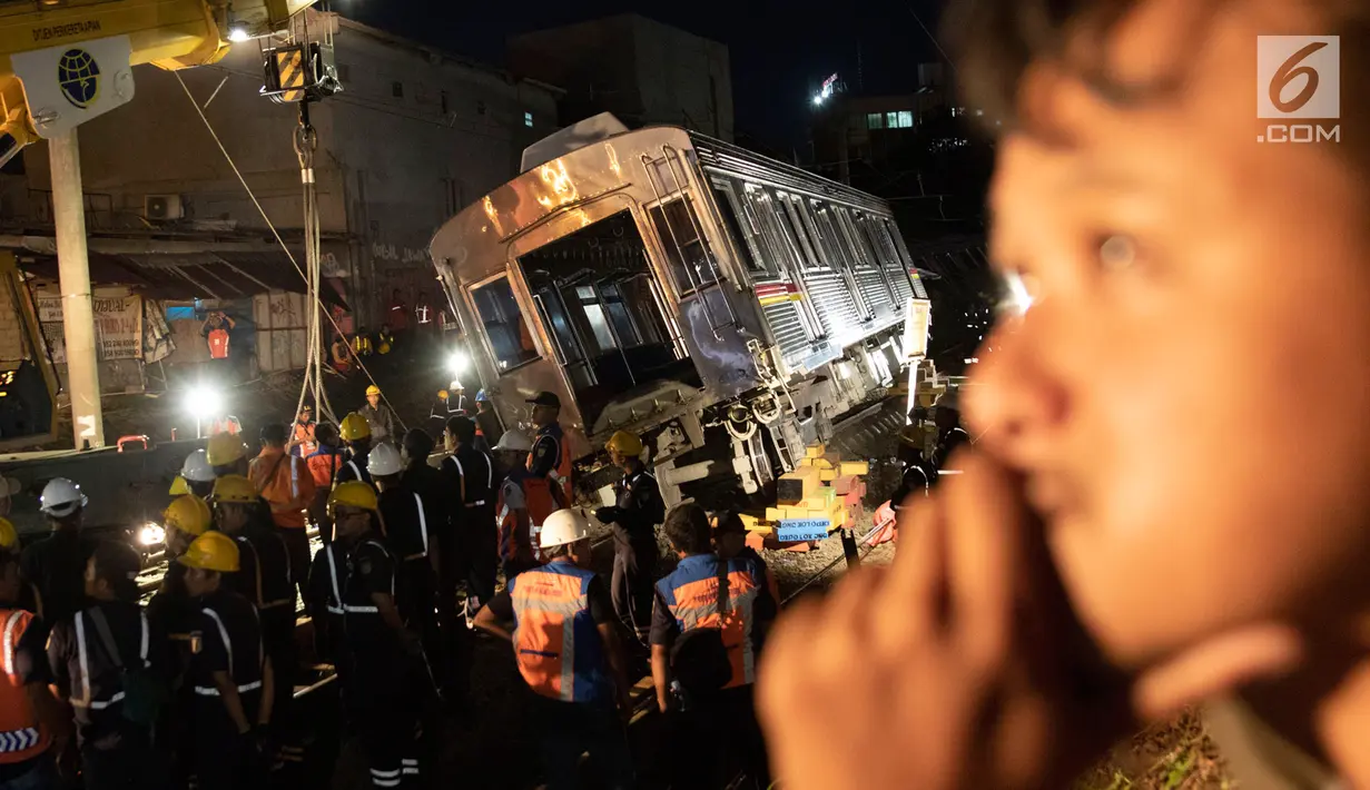 Petugas dibantu alat berat mengevakuasi gerbong KRL Commuter Line jurusan Jatinegara - Bogor di kawasan Kebon Pedes, Bogor, Jabar Minggu (10/3). Proses evakuasi menggunakan crane yang didatangkan dari Bandung. (Liputan6.com/Immanuel Antonius) 