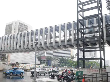 Kendaraan melintas jembatan penyeberangan orang (JPO) Bundaran Senayan di kawasan Jenderal Sudirman, Jakarta, Sabtu (5/1). Revitalisasi tiga di kawasan Sudirman ditargetkan selesai pada pertengahan Januari 2019. (Liputan6.com/Herman Zakharia)