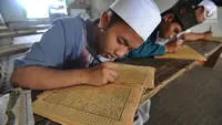 Beberapa santri memaknai Kitab Kuning saat mengaji 'Kilatan Kitab' di Pondok Pesantren Almiizan, Kabupaten Bogor, Senin (21/5). Ngaji kitab kuning ini merupakan tradisi di pondok pesantren pada saat bulan Ramadan. (Merdeka.com/Arie Basuki)